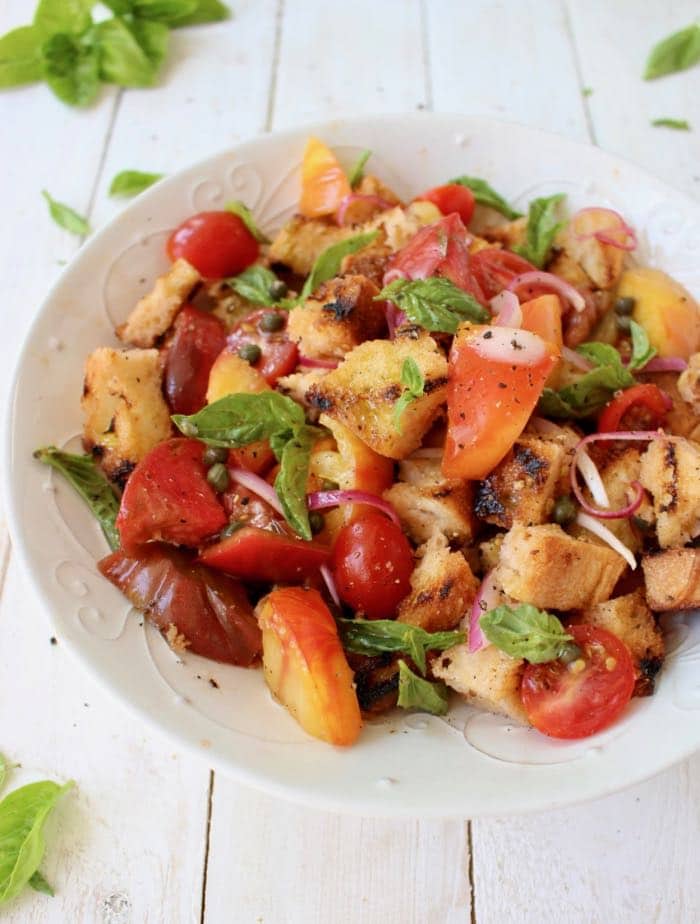 the best Panzanella bread salad recipe made with grilled bread, heirloom tomatoes, capers and herbs.