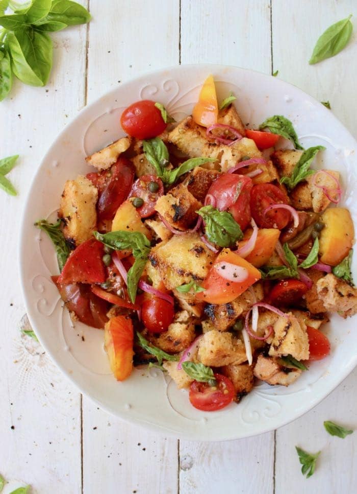 the best Panzanella bread salad recipe made with grilled bread, heirloom tomatoes, capers and herbs.