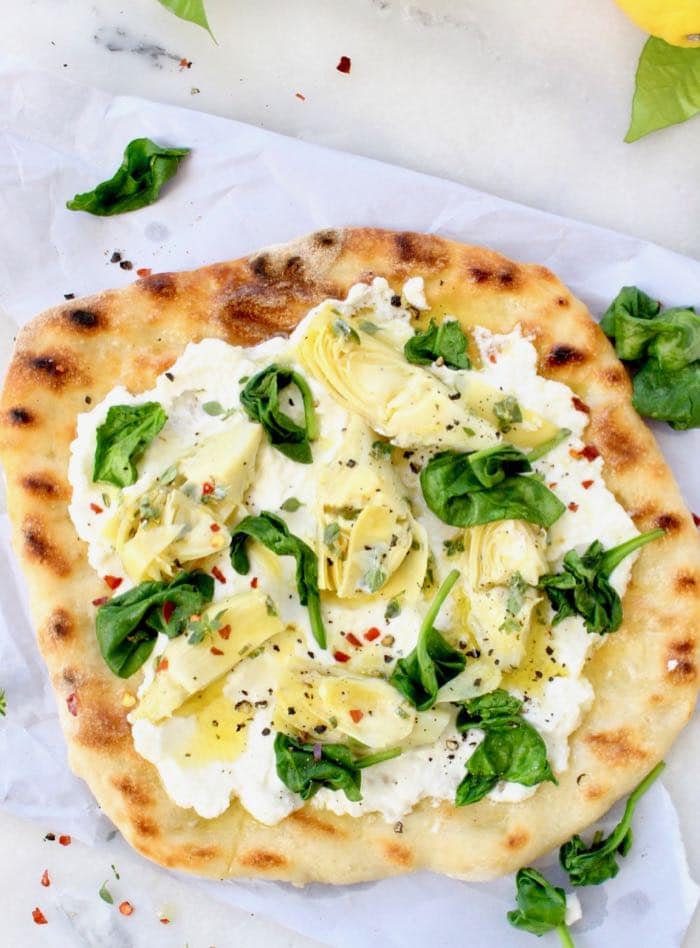Best vegan white pizza recipe made with garlic, spinach, artichokes and creamy homemade cashew ricotta cheese.