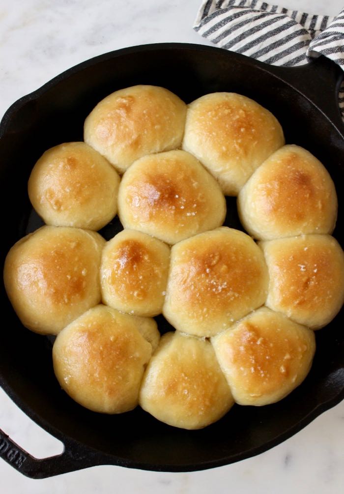 light and fluffy Vegan Dinner Rolls recipe Italian style with olive oil and sea salt in cast iron skillet.