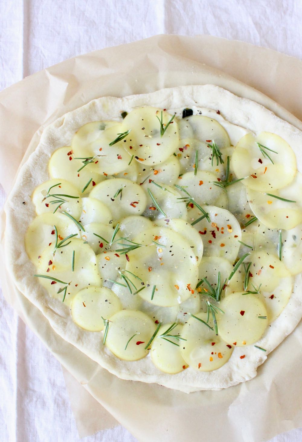 Step 2: cover pizza dough with thinly sliced potatoes and rosemary